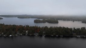 A Drone shot of murky foggy Lake Muskoka with treed islands and a wooded shoreline featuring lakefront homes and docks in Gravenhurst, Ontario, Canada - Powered by Shutterstock - Get 15% off with code: PIKWIZARD15
