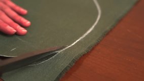 Tailor cuts fabric pieces along pattern on worktable. Sewing process in atelier, precision handmade tailoring - Powered by Shutterstock - Get 15% off with code: PIKWIZARD15