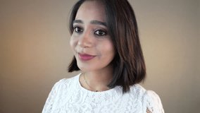 A Headshot closeup of happy smiling optimistic beautiful young South Asian woman lady cute girl looking at camera with confident calm - Powered by Shutterstock - Get 15% off with code: PIKWIZARD15