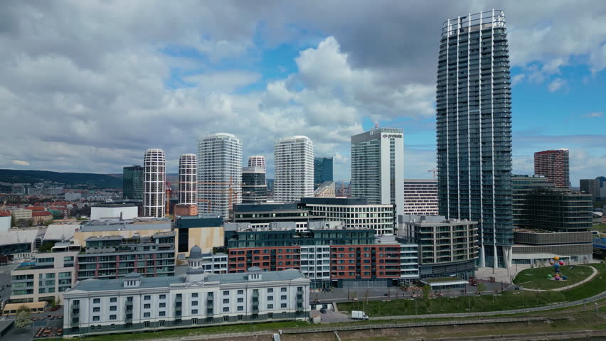 An aerial view of the city skyline in Bratislava, with a dense cluster of modern residential skyscrapers dominating the newer urban center in Slovakia