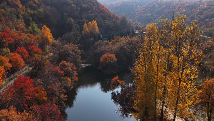 Soldier Lake. A lake in a mountainous area with different vegetation. Bright juicy autumn leaves, leaf fall and reflection in the water.