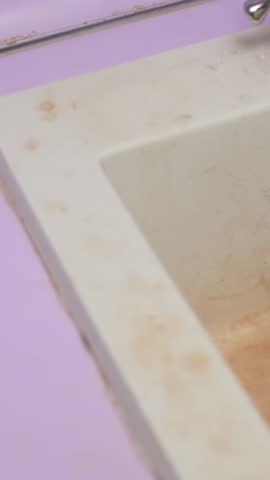 Dirty kitchen sink with stained surface and worn-out drain, showing buildup of grime and signs of long-term neglect.