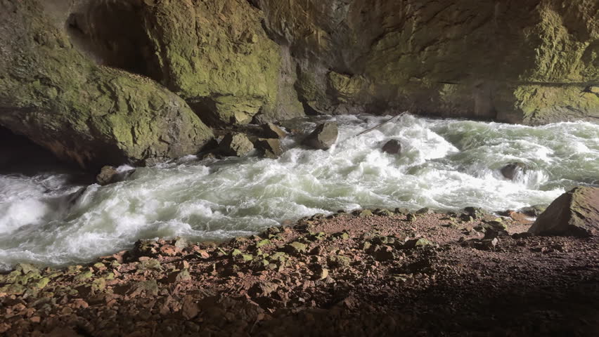 Underground river flowing inside Tkalca Cave in Slovenia