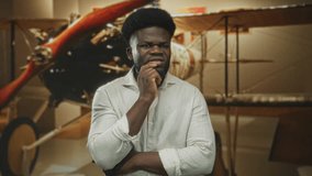 Man hand on chin in museum building beside vintage airplane propeller, looking pensive and studying the display; thoughtful. - Powered by Shutterstock - Get 15% off with code: PIKWIZARD15