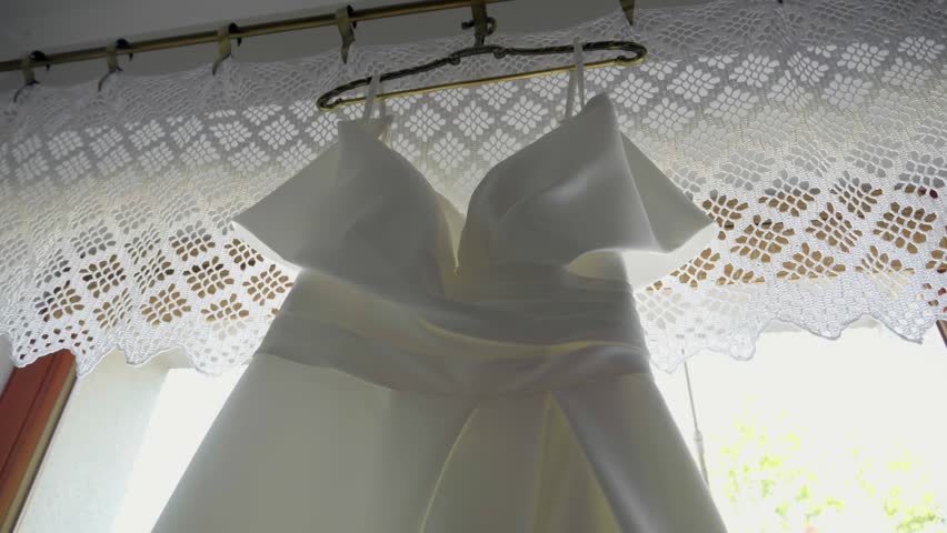 Close-Up of Wedding Dress Hanging in Bright Window Light
