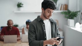Video of businessman using smartphone while drinking a cup of coffee sitting on a desk in a coworking place - Powered by Shutterstock - Get 15% off with code: PIKWIZARD15