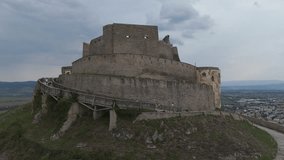 Aerial Orbit around the Fortress of Deva, capturing its ancient stone walls set against dramatic, moody skies. - Powered by Shutterstock - Get 15% off with code: PIKWIZARD15
