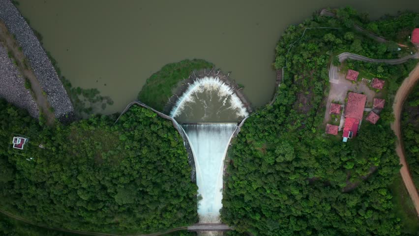 Top down view of El Carrizo Dam spilling water, surrounded by forest and buildings near Tamazula de Gordiano, Jalisco