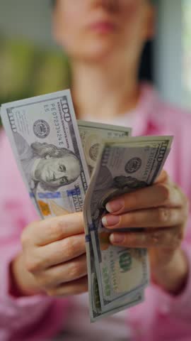 Woman counting US Dollar bills, close-up. Vertical video