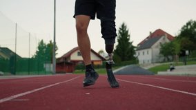 Determined athlete using a prosthetic running leg, a blade with a heel plate to jump on the track, close up. Strength, agility, and motivation concepts. - Powered by Shutterstock - Get 15% off with code: PIKWIZARD15