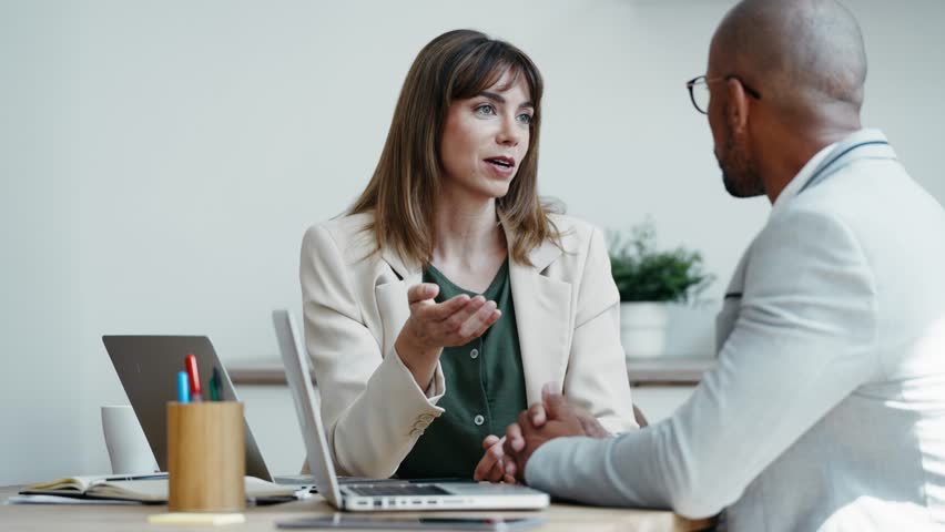 Video of smart business people working together with laptop while talking in a modern startup