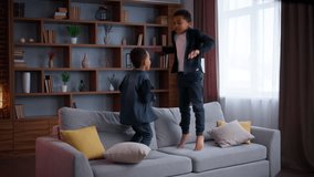 Two naughty African American little boys jumping on sofa children at home hyperactive siblings brothers kids sons jump on couch fooling around carefree family having fun joy playing ADHD behavior - Powered by Shutterstock - Get 15% off with code: PIKWIZARD15