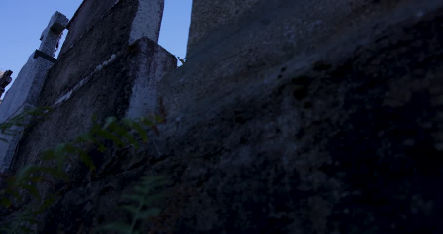 A church steeple with a bell tower. The sky is clear and blue. The church is old and has a stone exterior