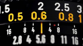 Macro focus pull on black vintage camera lens with orange distance scale numbers - Powered by Shutterstock - Get 15% off with code: PIKWIZARD15