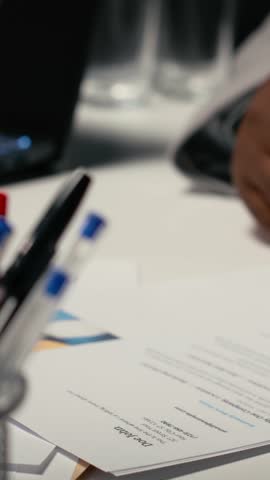Vertical Video Close up of CV document evaluation in a corporate job interview, businesswoman asking african american candidate questions based on his past work experience and studies shown on paper