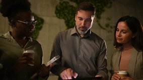 Group of multi ethnic business people using a digital tablet for a presentation, laughing and drinking coffee in a modern office - Powered by Shutterstock - Get 15% off with code: PIKWIZARD15