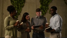 Multiethnic group of colleagues collaborating on a new project. Business professionals standing and using a digital tablet during a coffee break - Powered by Shutterstock - Get 15% off with code: PIKWIZARD15