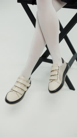 Beige velcro sneakers and white tights in fashion shoot