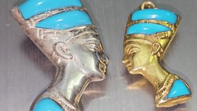 pendants of gold and silver featuring bust of queen Nefertiti the wife of the Pharaoh Akhenaten, during the 18th Dynasty, Her name means (the beautiful one has arrived), precious metal pendants - Powered by Shutterstock - Get 15% off with code: PIKWIZARD15