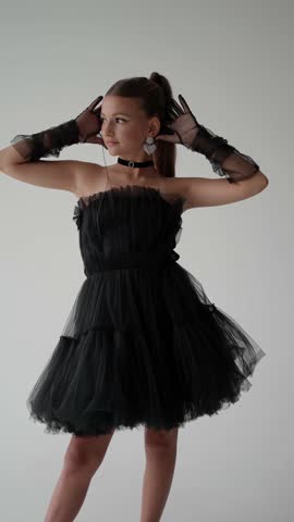 Fashionable portrait of a teenage girl in a black tulle dress. Fashionable child concept.