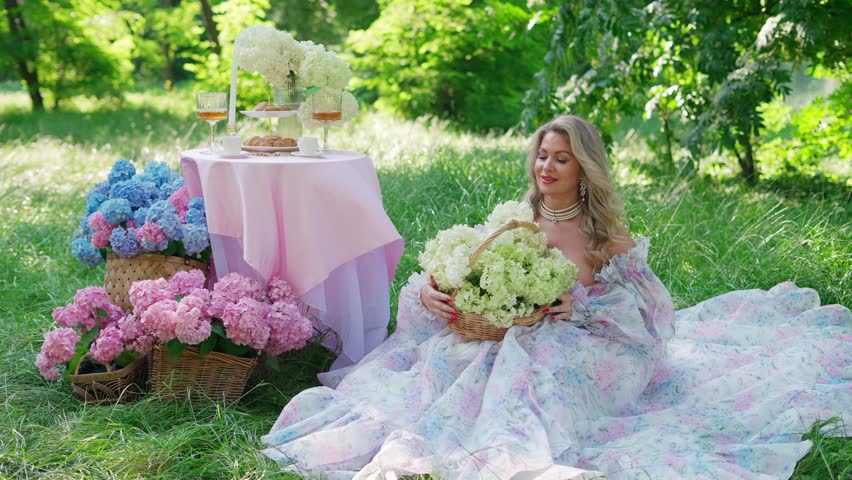 Elegant woman in floral dress sitting in the garden. Concept of woman with bouquet of flowers.