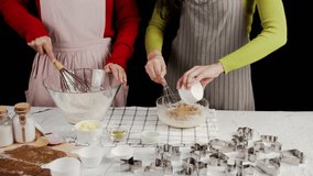 Two people preparing cookie dough together, adding ingredients and whisking in glass bowls surrounded by baking tools and cutters, capturing a warm homemade baking moment in a cozy kitchen - Powered by Shutterstock - Get 15% off with code: PIKWIZARD15
