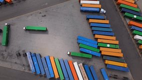 Top-down view of trucks maneuvering among colorful containers at logistics yard, October 7, 2025 - Powered by Shutterstock - Get 15% off with code: PIKWIZARD15