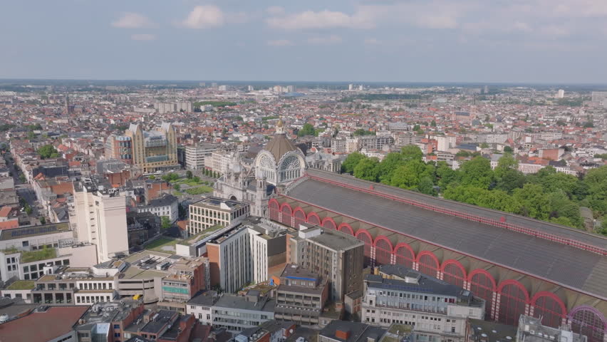 Aerial view of Antwerp Central Station with a camera panning slowly to the right, revealing the cityscape of Antwerp, Belgium