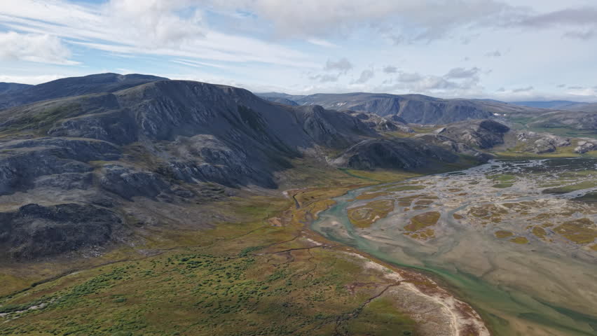 Smooth flythrough of a turquoise river threading a tundra valley. Sandbar, oxbow and wetlands appear in rich detail under sunny midday sky. Location Russia, Chukotka, Lavrentiya Bay