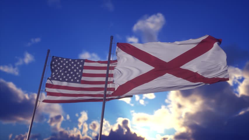 American and Alabama Flags Waving Against Blue Sky With Dramatic Sunlight