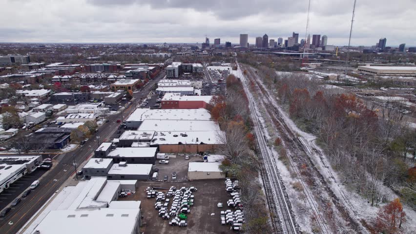 Wintry landscape with snow, cold, and ice from drone aerial above central Ohio midwestern city of Columbus, OH in North America in early winter as white frost sits on building roofs in neighborhood