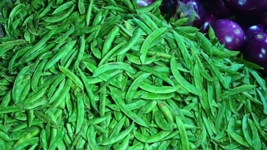 Hyacinth bean pods or sem ki fali are arranged in a pile for sale at a shop, displaying green curved shapes.