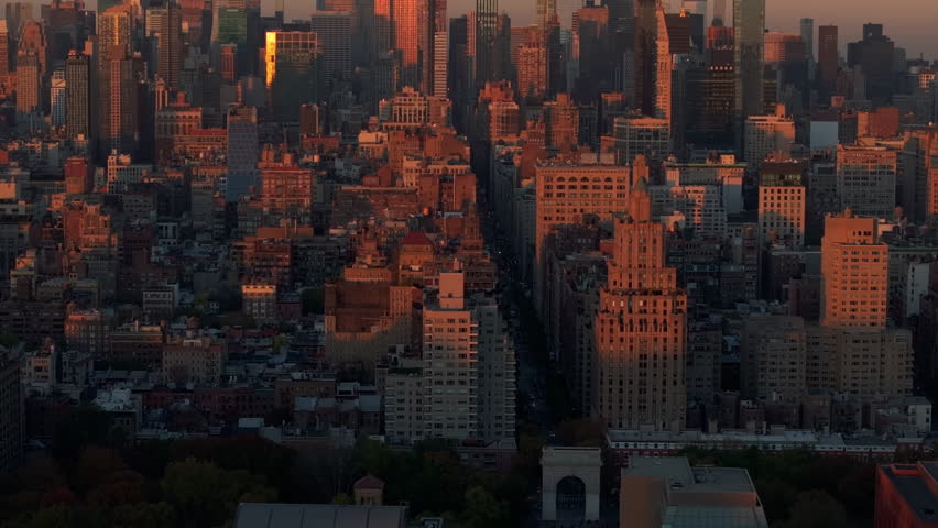 Warm sunlight envelops Washington Square Park in the Greenwich Village neighborhood of Lower Manhattan in New York City during golden hour