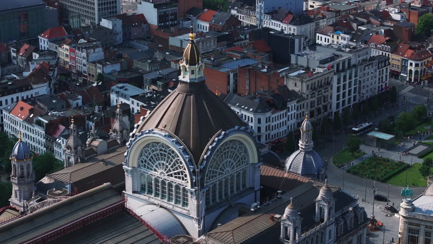 Aerial views circling the dome of Antwerp Central Station reveal the lively urban landscape of Antwerp, Belgium, showcasing its historic architecture and vibrant city life