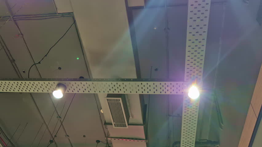 Ceiling lights and AC vents align with structured lines in an office setup, showing organized design layout.