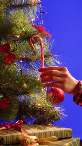 Hand woman decorating on Christmas tree with Christmas glow lights macro, decoration for new year eve.