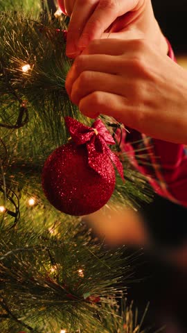 Hand woman decorating on Christmas tree with Christmas glow lights macro, decoration for new year eve.