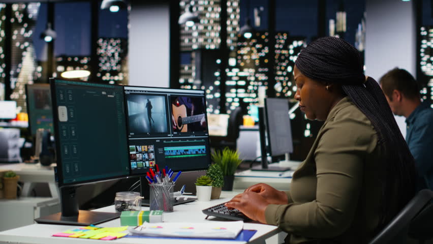 Female editor taking a painkiller to calm her severe headache, dealing with burnout and weariness due to overload at night. Under pressure and stressed to finish editing project in time. Camera B.
