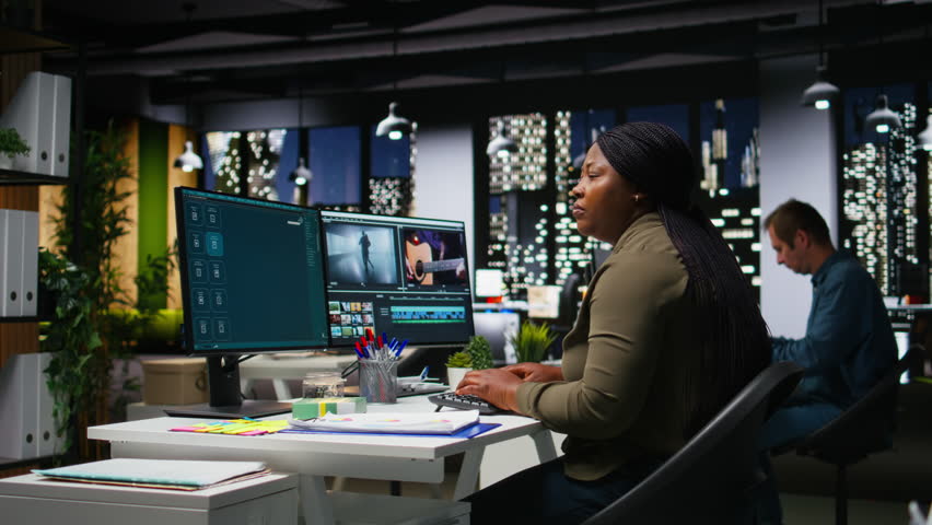 Female editor taking a painkiller to calm her severe headache, dealing with burnout and weariness due to overload at night. Under pressure and stressed to finish editing project in time. Camera A.