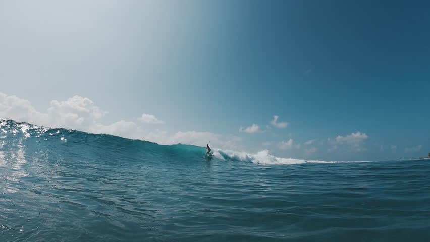 Male surfer rides the fast ocean wave