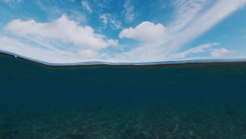 Underwater view of the ocean wave breaking on the shore during sunset light in the Maldives