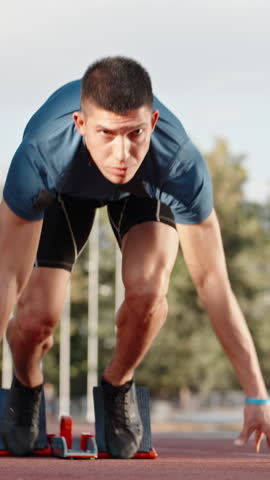 athlete sprinter starting run on stadium vertical slow motion fullHD early morning light motivation power discipline determination speed focus strength healthy lifestyle inspiration