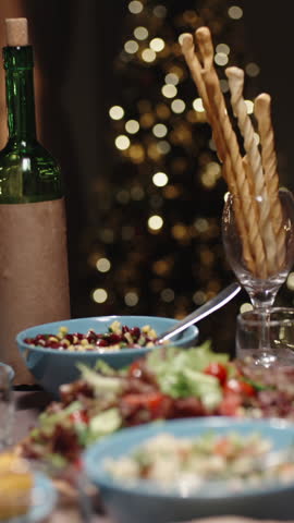 Vertical slow motion video cinematic camera moving above festive dinner table red wine glasses meeting in toast concept celebration togetherness thanksgiving christmas cozy home light