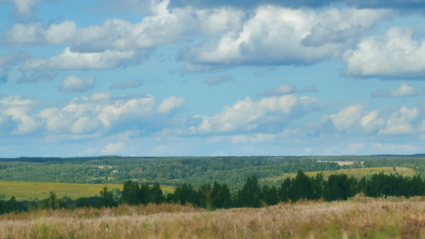 A stunningly beautiful landscape featuring rolling hills beneath dramatic, billowing clouds