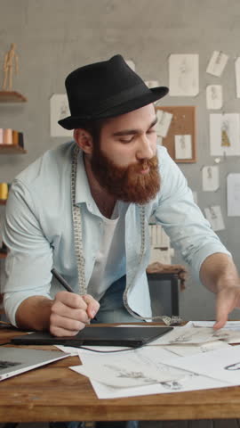 creative fashion designer sketching new collection in modern studio stylish male artist building sustainable brand digital fashion concept vertical slow motion fullhd video