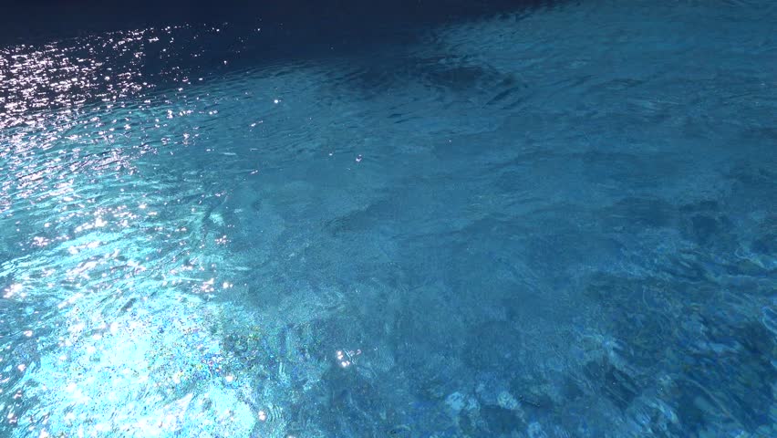 Sousse, Tunisia A man swims breaststroke in a blue outdoor pool. 