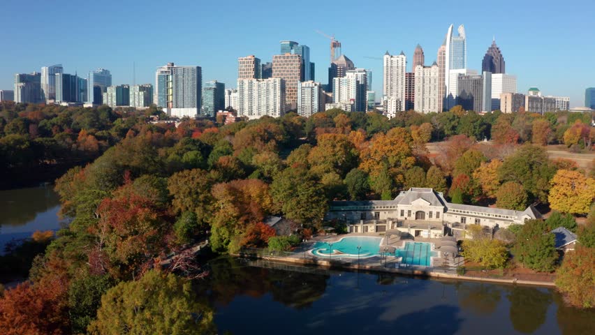 Flying over Piedmont Park above the public pool looking at downtown Atlanta Georgia