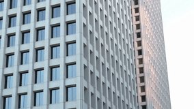 Exterior view of windows on a large modern office building, reflecting city skyline and clouds, symbolizing business, architecture, and corporate life. - Powered by Shutterstock - Get 15% off with code: PIKWIZARD15