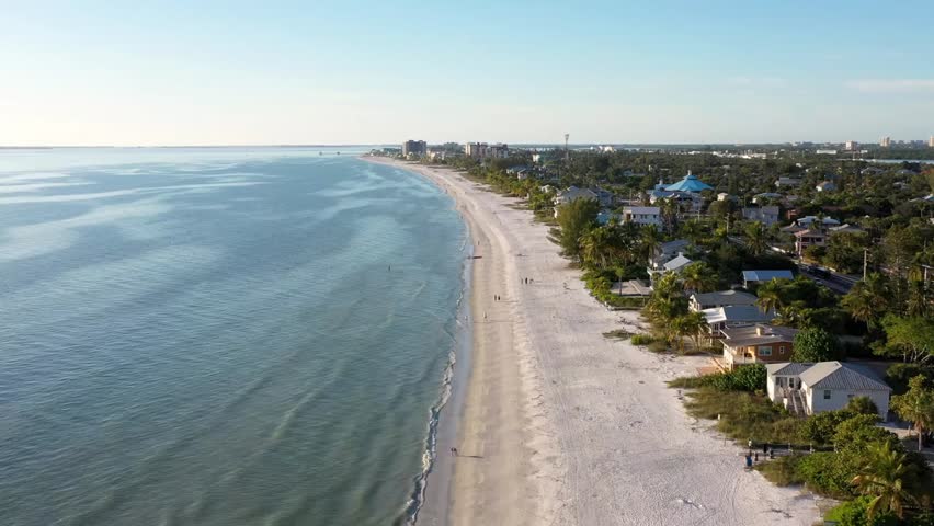 Aerial view of the coastline along Fort Myers Beach, Florida, showing turquoise waters, sandy shores, and scenic coastal beauty in sunny weather.