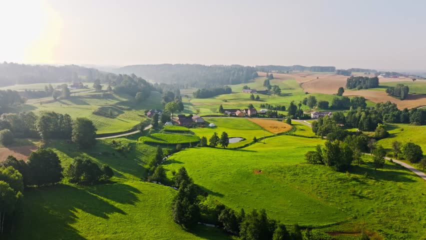 Peaceful morning landscape of rolling fields and village houses in Poland